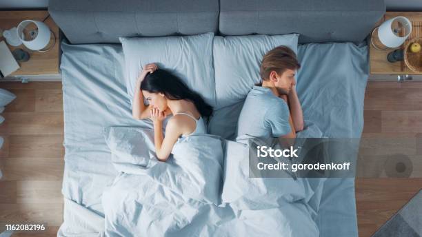 Quarrelling Jong Stel In Het Bed Jonge Mensen Liegen Zich Van Elkaar Af En Lag Aan Hun Zijde Met Wrogen En Beledigd Stockfoto en meer beelden van Koppel