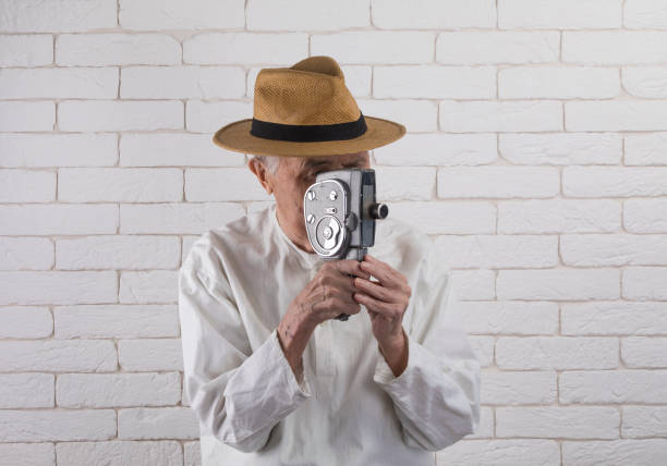 Man using old fashioned cine camera, black and white image