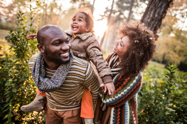 parents noirs heureux ayant l'amusement avec leur fille au stationnement. - activités de week end photos et images de collection