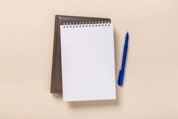 istock school notepad and pen on the beige desk. spiral notepad on a table 1162083795
