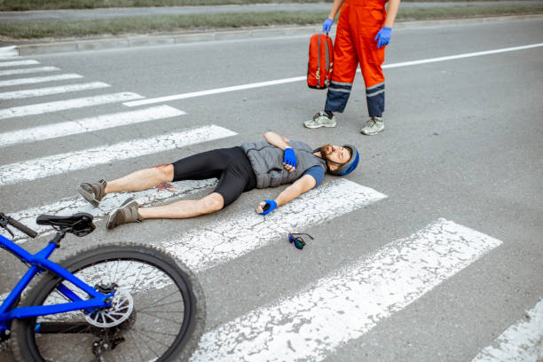 istock Road accident with injured cyclist and medic going to help 1162084006