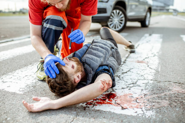istock Medic applying first aid to the bleeding person on the road 1162084821