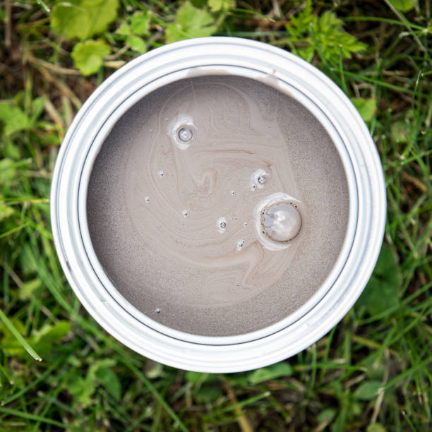 istock Open can of brown color paint on green grass 1162084918