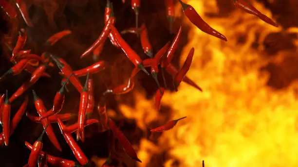 Red hot chilli peppers flying in freeze motion in flames.