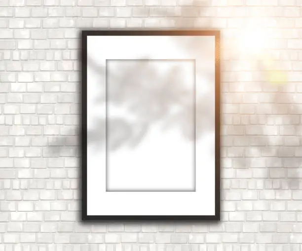 3D render of a blank picture frame on brick wall with shadow and sunshine overlay