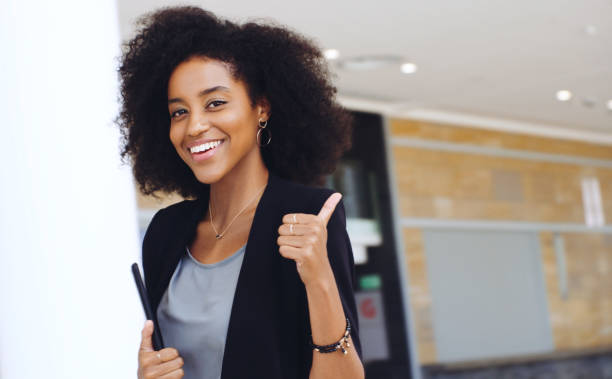 It's all systems go Portrait of a confident young businesswoman showing a thumbs up gesture in a modern office professional thank you stock pictures, royalty-free photos & images
