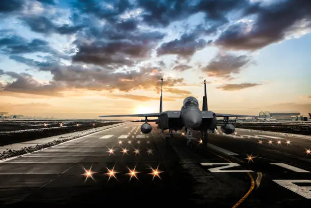 Photo of F-15 Eagle jet fighter ready to takeoff on runway at sunset