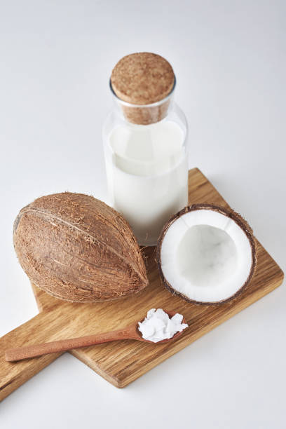 istock Coconut with cracked half and milk on a white background, top view 1162101300