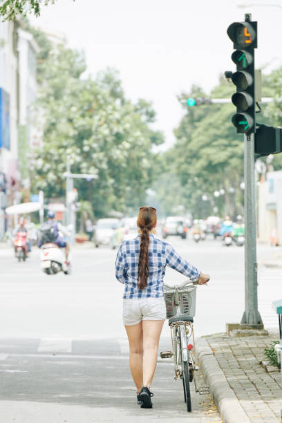 istock Young woman walking with bicycle 1162102078