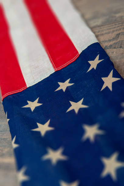 an American flag lying on an aged, weathered rustic wooden background.