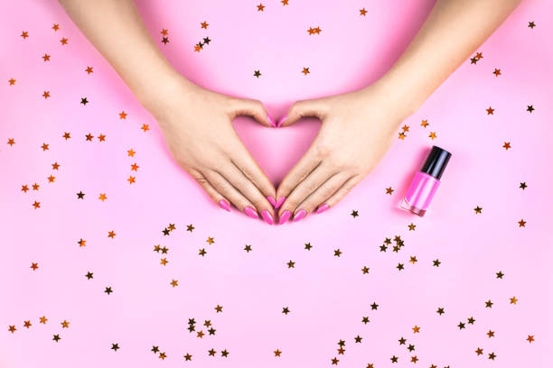 istock Woman's hand with Coral manicure making heart. 1162105744