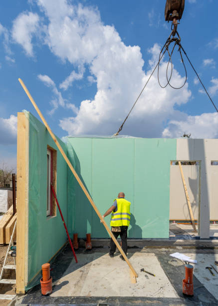 istock Process of construction new and modern modular house from composite sip panels. Workman in special protective uniform wear working on building development industry of energy efficient property 1162108988