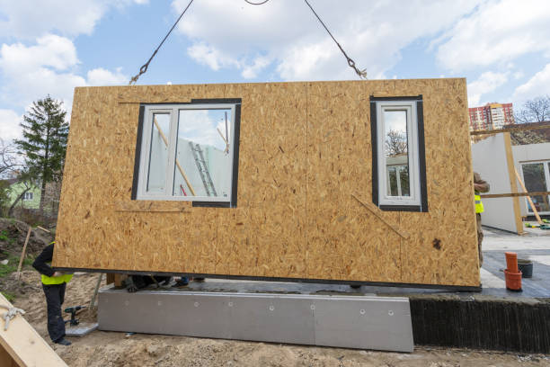 proceso de construcción nueva y moderna casa modular. trabajador en uniforme de protección especial desgaste de pie detrás de panel de sorbo y trabajando en la industria de desarrollo de edificios de propiedad energéticamente eficiente - prefabricate fotografías e imágenes de stock