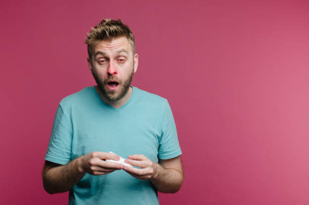 studio picture from a young man with handkerchief going to sneeze. Sick guy isolated has runny nose. man makes a cure for the common cold studio picture from a young man with handkerchief going to sneeze. Sick guy isolated has runny nose. man makes a cure for the common cold from the air conditioner sneezing stock pictures, royalty-free photos & images