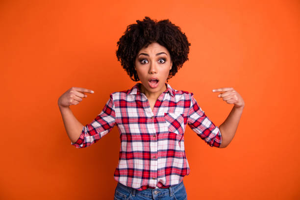 istock Portrait of her she nice-looking attractive scared afraid puzzled confused wavy-haired lady in checked shirt recommending self isolated on bright vivid shine orange background 1162110398