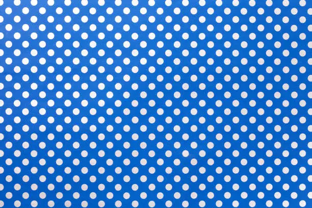 Photo of Navy blue background from wrapping paper with a pattern of silver polka dot closeup.
