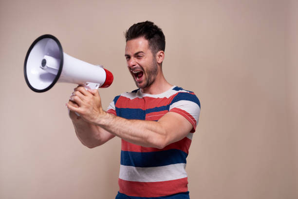 istock Screaming man with megaphone in studio shot 1162114937