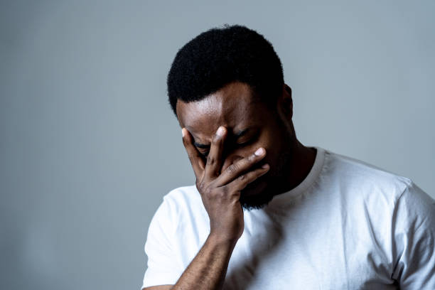 retrato de hombre atractivo triste y deprimido sufriendo depresión sintiendo dolor y dolor desagradable en las emociones humanas expresiones faciales y concepto de depresión. aislado sobre fondo azul gris. - men mental illness loss despair fotografías e imágenes de stock