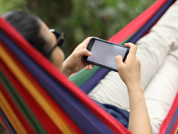 istock Relaxing in hammock with smartphone in forest 1162117223