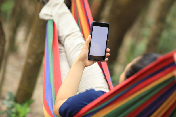 istock Relaxing in hammock with smartphone in forest 1162117255