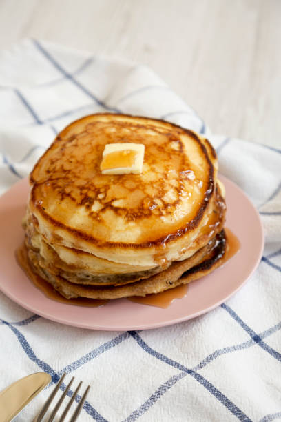 istock Homemade pancakes with butter and maple syrup on a pink plate, low angle view. 1162117280