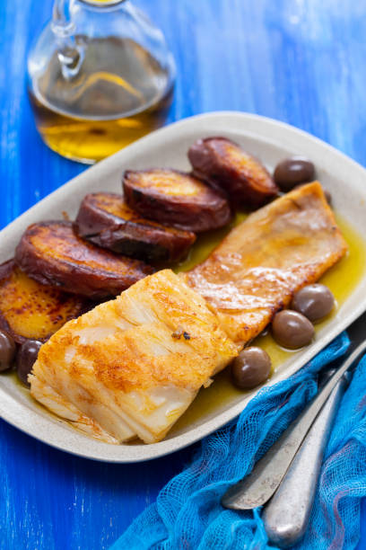 istock fried cod fish with olives and sweet potato on dish 1162117601