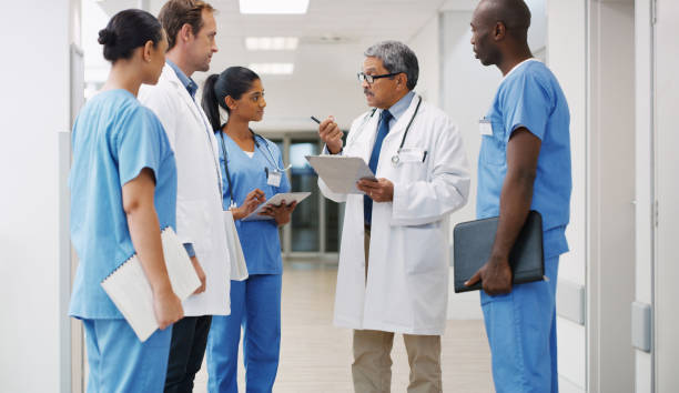 They're all trained and experienced to handle any medical matter Shot of a group of medical practitioners having a discussion in a hospital medical occupation stock pictures, royalty-free photos & images