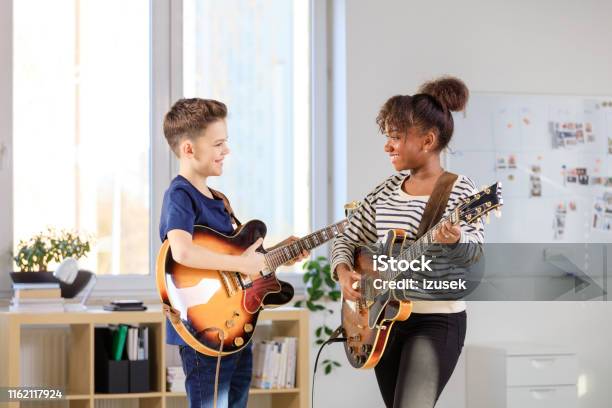 Male Student Learning Guitar From Trainer Stock Photo - Download Image Now - Teenager, Boys, Confidence