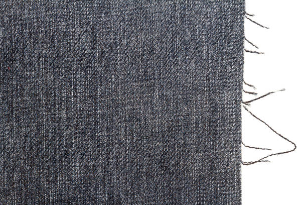 Piece of dark jeans fabric Piece of dark jeans fabric isolated on white background. Rough uneven edges. fabric edge stock pictures, royalty-free photos & images
