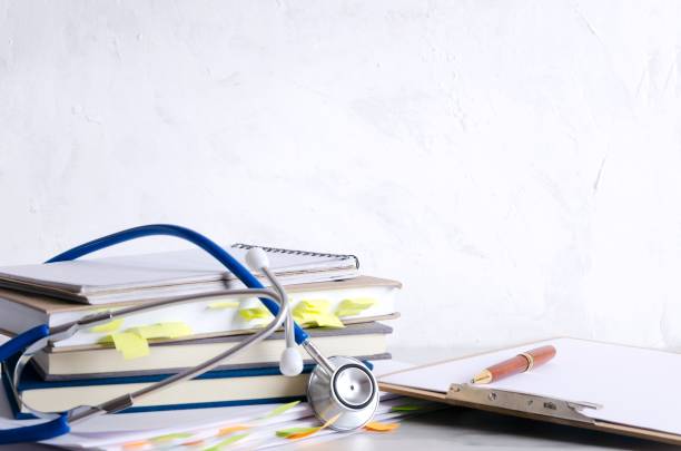 istock Anamnesis, stethoscope, clipboard with blank paper, pen on the table against white wall.Concept of hospital reception and prescription 1162119232