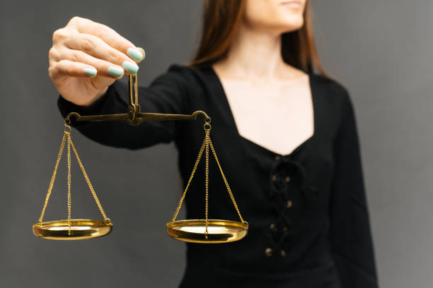 istock Serious woman holding the justice scale on dark background 1162119558