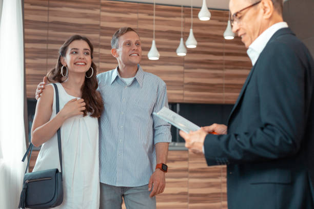 istock Couple looking at Real Estate Agent preparing documents for buying house 1162119607