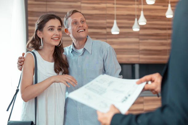 istock Couple looking at Real Estate Agent giving them the documents 1162119608