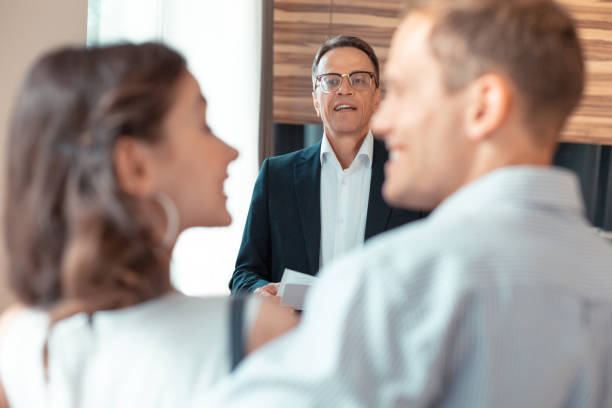 istock Mature Real Estate Agent looking at couple while talking to them 1162119621