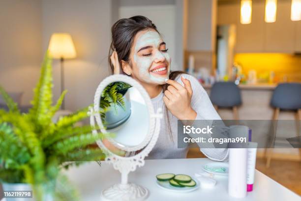 Attractive Young Woman Sitting With A Facial Mask On Her Skin Stock Photo - Download Image Now