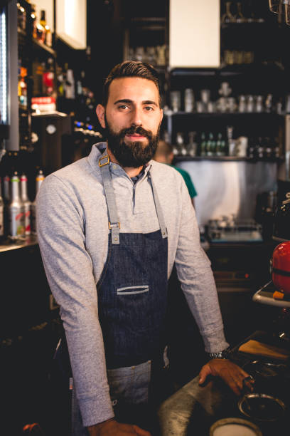 istock Positive young bearded barista at his work 1162120473