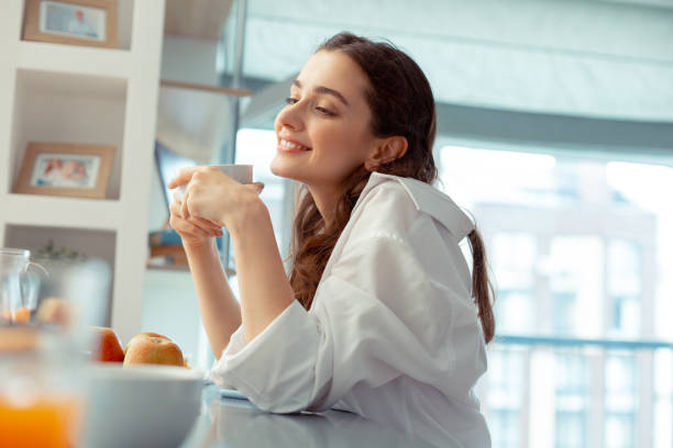 istock Woman wearing white shirt feeling relaxed drinking coffee 1162121830