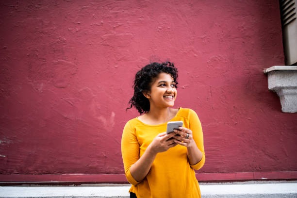 istock Smiling Indian woman using mobile phone 1162122605
