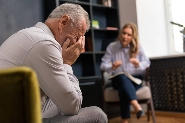 istock Depressed grey-haired man covering his face with hands 1162122771