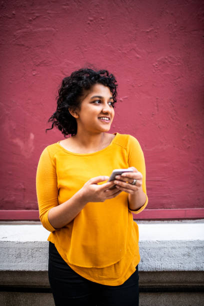 istock Smiling Indian woman using mobile phone 1162122791