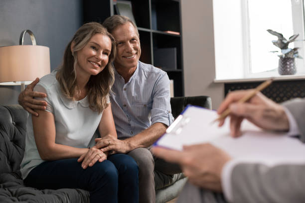 istock Husband hugging his wife in front of a psychoanalyst 1162122815