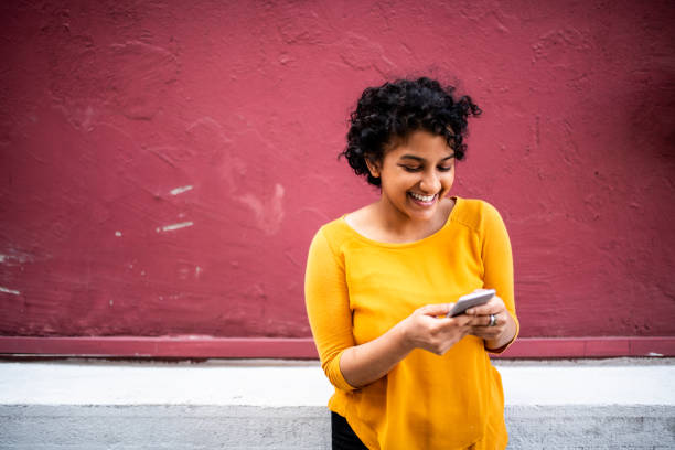 istock Smiling Indian woman using mobile phone 1162123091