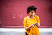 Smiling Indian woman using mobile phone