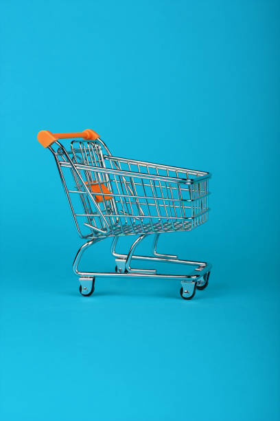 istock Close up retail shopping cart on blue background 1162124176