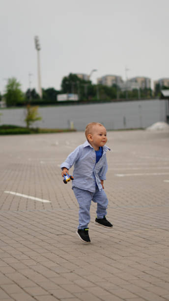 istock Little funny boy jumps on the square with gray pavement 1162124692