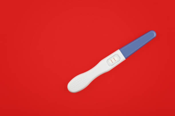 istock Close up positive pregnancy test over red 1162125559