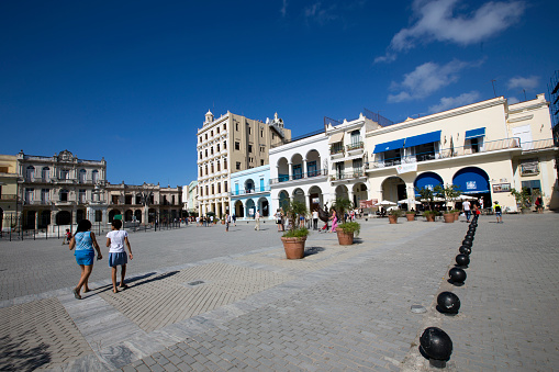 Plaza Vieja, people and tourists walking in the popular square with restored historic buildings in Habana Vieja, Havana, Cuba