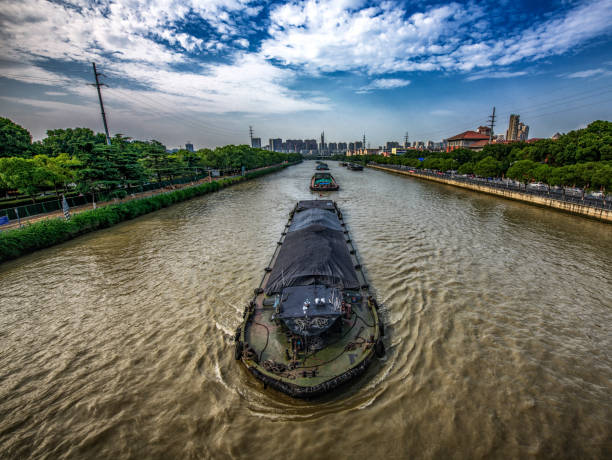 Boats on the Grand Canal of China A wide angle view of this impressive canal in Wuxi, China grand canal china stock pictures, royalty-free photos & images