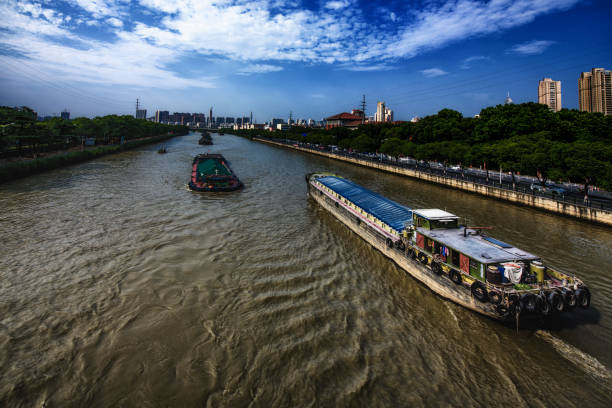 Industrial Ships at the Grand Canal of China Fluid traffic at this impressive canal in Wuxi, China. grand canal china stock pictures, royalty-free photos & images