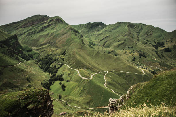 A mountain range covered in green grass and with a narrow road on it